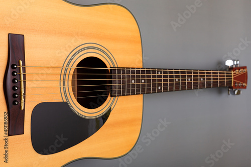  upper soundboard of an acoustic yellow guitar close-up on a gray background