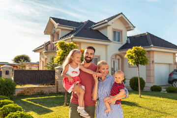 Parents and children standing in front of their new house