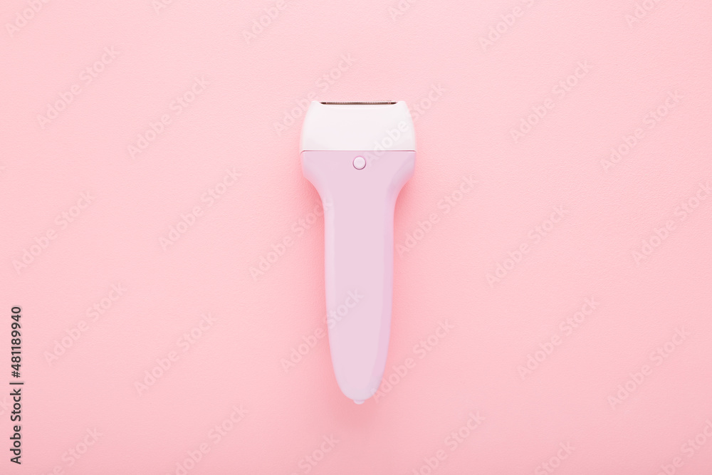 Electric epilator on light pink table background. Pastel color. Closeup. Female product for smooth body skin. Top down view. Electric epilator on light pink table background. Pastel color. Closeup. Female product for smooth body skin. Top down view.