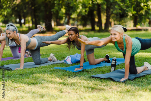 Multiracial women doing exercise during yoga practice in park