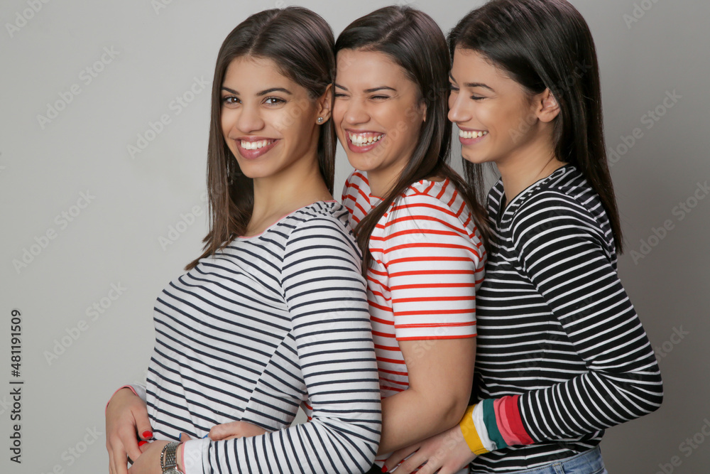 Three happy beautiful Caucasian women in striped t-shirts, Studio shot Three happy beautiful Caucasian women in striped t-shirts, Studio shot