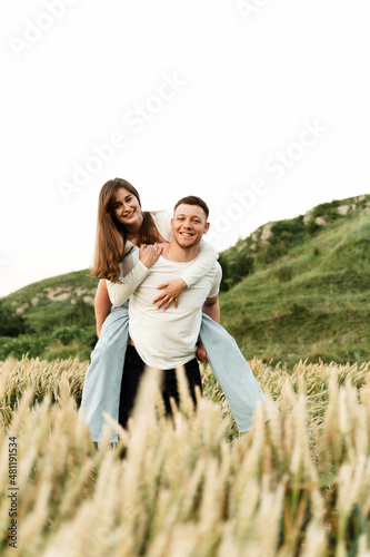 lovers in a wheat field play and laugh. romantic relationship of a modern couple. lovers walk in nature.