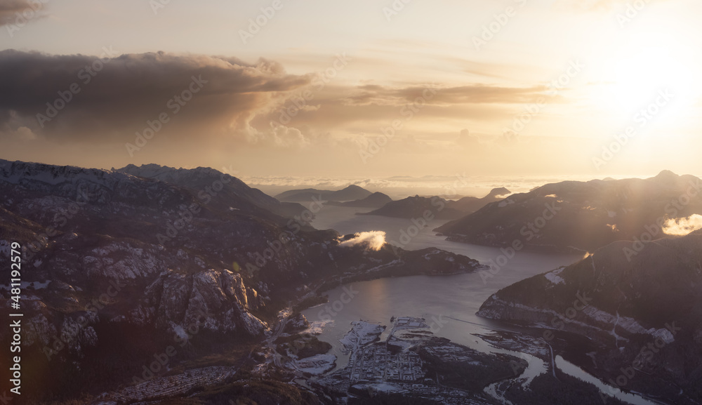 Aerial View of a small city, Squamish, in Howe Sound during winter season. Located north of Vancouver, British Columbia, Canada. Dramatic Sunset Sky Art Render