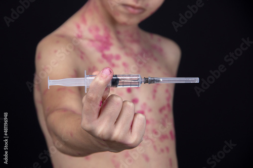 Wallpaper Mural A boy is holding a syringe with a vaccine for the virus in his hand. Torontodigital.ca