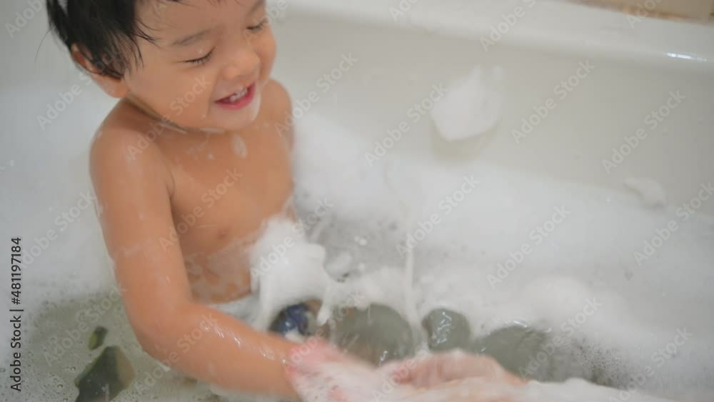 A Baby boy bathes in a bath with foam and soap bubbles A Baby boy bathes in a bath with foam and soap bubbles