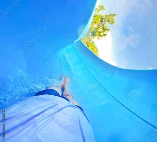 man sliding down on blue waterslide