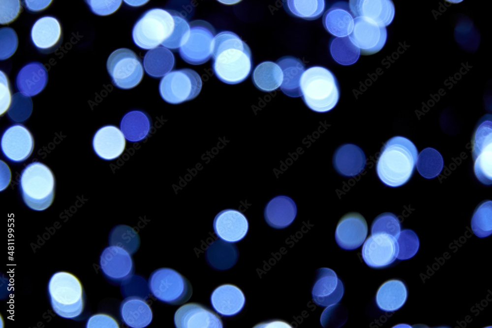 Naklejka premium Defocused bokeh christmas cold lights on black background. Blue bokeh glitter wallpaper. Christmas theme, New year or festival background. Abstract blurred blue glitter texture.
