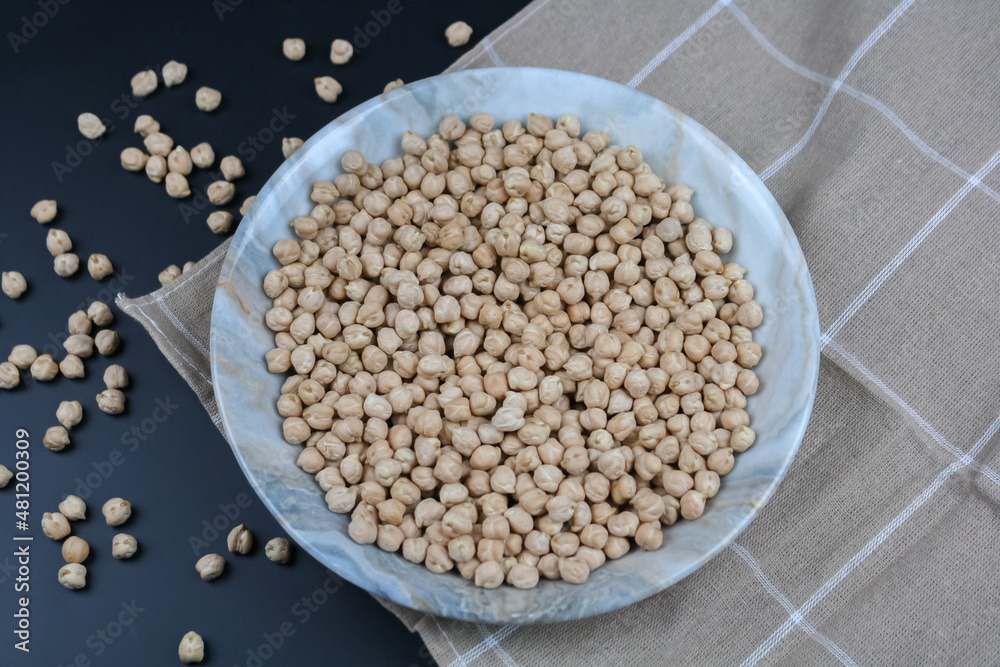 Raw chickpeas on the plate and towel top view. Raw chickpeas on the plate and towel top view.