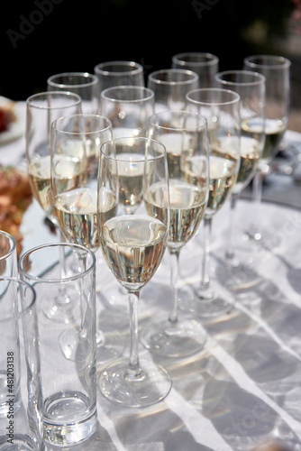 Sparkling glassware with wine and champagne on dinner table in restaurant, copy space. Crystal glasses ready for celebration. Wineglasses at luxury wedding reception