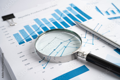 Magnifying glass on charts graphs paper. Financial development, Banking Account, Statistics, Investment Analytic research data economy, Stock exchange trading, Business office company meeting concept. photo