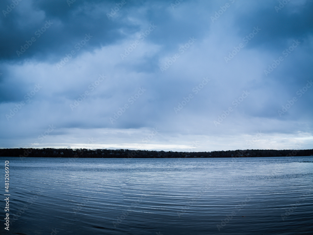 Moody dark cloudscape at twilight over the frozen lake in the winter on Cape Cod Moody dark cloudscape at twilight over the frozen lake in the winter on Cape Cod