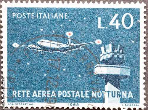 Italy - circa 1965: a postage stamp from Italy showing an airplane at the night-flying aircraft and control tower