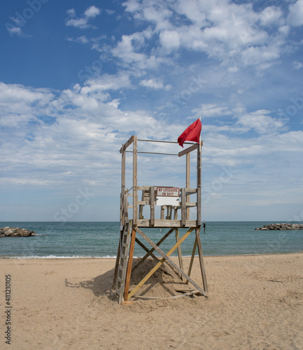 Lifeguard station at a sandy beach on a lake with clouds and blue sky and 