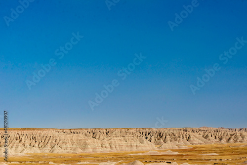 A vibrant  clear  blue sky over layered sandstone formations in Badlands National Park  South Dakota.