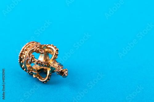 Small golden crown on blue background.