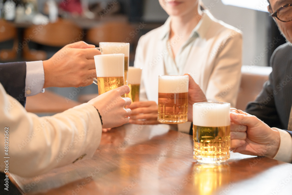 ビールで乾杯する会社帰りの打ち上げ飲み会手元 ビールで乾杯する会社帰りの打ち上げ飲み会手元