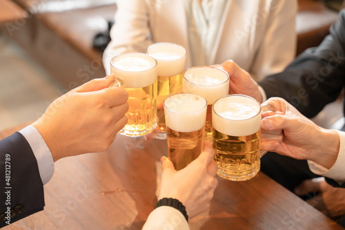 ビールで乾杯する会社帰りの打ち上げ飲み会手元