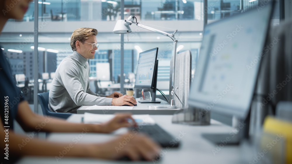 Big Diverse Corporate Office: Portrait of Handsome Manager Using Desktop Computer, Businessman Managing Company Operations, Analysing Statistics, Commerce Data, Marketing Plans. Big Diverse Corporate Office: Portrait of Handsome Manager Using Desktop Computer, Businessman Managing Company Operations, Analysing Statistics, Commerce Data, Marketing Plans.