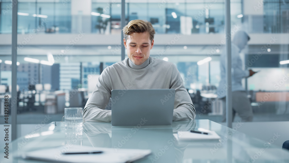 Obraz premium Successful Handsome Businessman Working on Laptop Computer in Big City Office. Finance Investment Analyst Checking Analytics from Project Management Reports, Answering Emails, Checking Social Media.