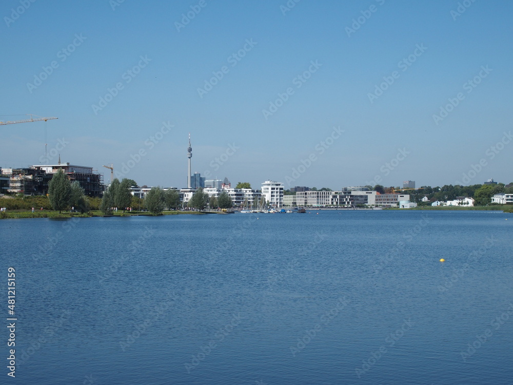 View of Phoenix Lake in the Dortmund suburb of Hoerde, North Rhine-Westphalia, Germany, a renatured industrial wasteland, in the background left the Dortmund TV tower