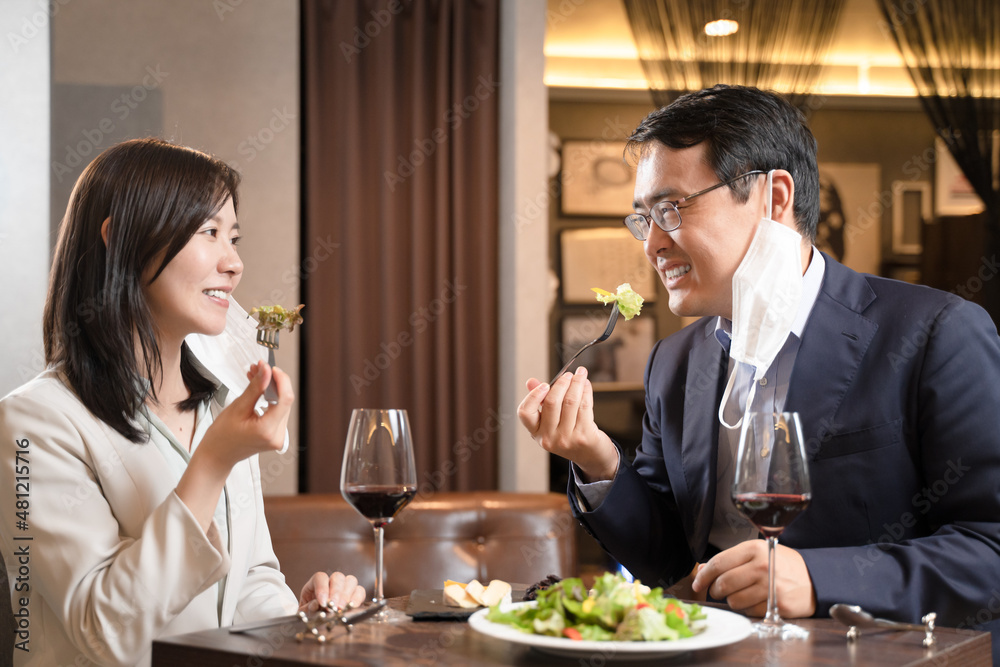 飲食店でマスク会食をする男女