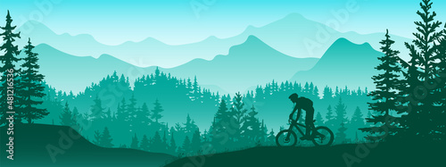 Silhouette of mountain bike rider in wild nature landscape. Mountains, forest in background. Magical misty nature. Blue and green illustration. photo