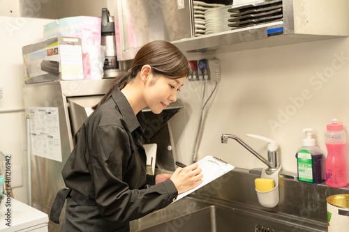 食品衛生管理をチェックする女性スタッフ photo