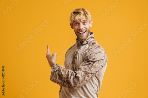 Obraz na plátně White military man wearing uniform smiling and pointing finger upward