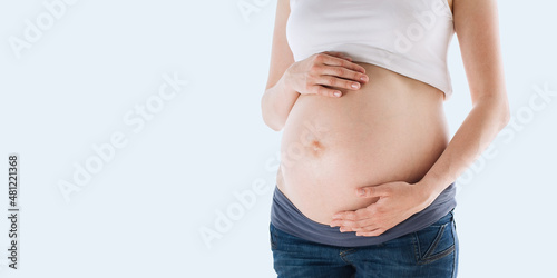 Pregnant woman isolated over grey color background © D'Action Images