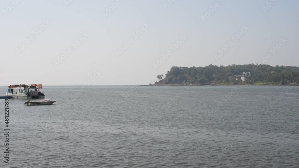 HD scenery of the Mandovi river and marina in Goa with fishing vessel and a yacht in the foreground HD scenery of the Mandovi river and marina in Goa with fishing vessel and a yacht in the foreground