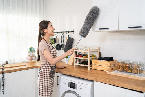 Asian cleaning service woman worker cleaning in kitchen room at home.  photo