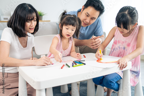 Asian happy family young couple teach little girl paint in living room. 