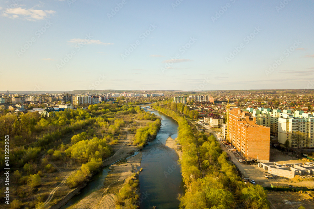 Fototapeta premium Aerial view of tall residential apartment buildings under construction and Bystrytsia river in Ivano-Frankivsk city, Ukraine