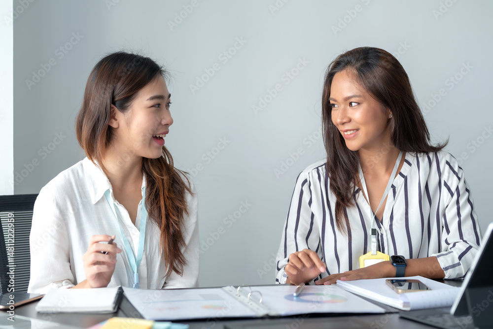 Two beautiful Asian businesswoman talking exchange ideas at work. Two beautiful Asian businesswoman talking exchange ideas at work.