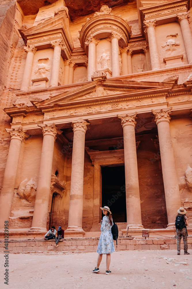 Girl tourist with a backpack in front of the Treasury in Petra, Jordan