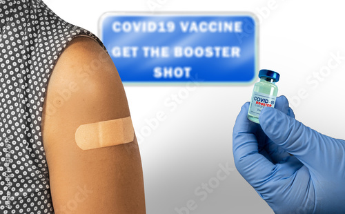 Vaccination clinic for covid 19 vaccine booster shot. A patient and the booster vaccine bottle. Sign with 'Covid-19 Vaccine Get the Booster shot'. 