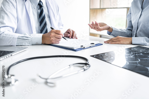 Professor Doctor consulting with patient discussing something and recommend treatment methods, Presenting results on report and x-ray film, Medicine and health care concept