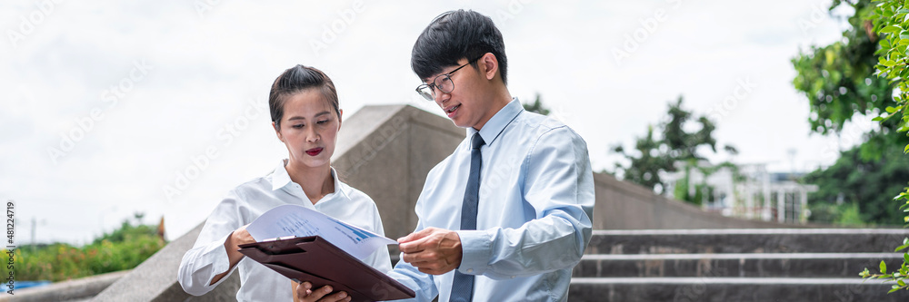 Young business woman and businessman talking and looking investment chart report Young business woman and businessman talking and looking investment chart report