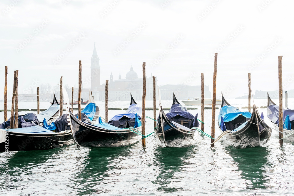 Gondolas moored on channel with historic basilica view Gondolas moored on channel with historic basilica view