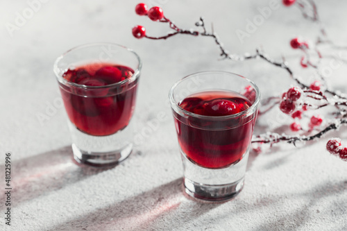 Two glasses of cherry liqueur on white background