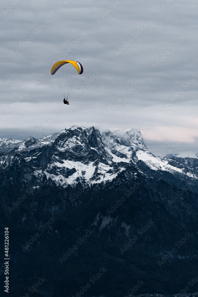 Traveler flying on paraglider over mountains Traveler flying on paraglider over mountains