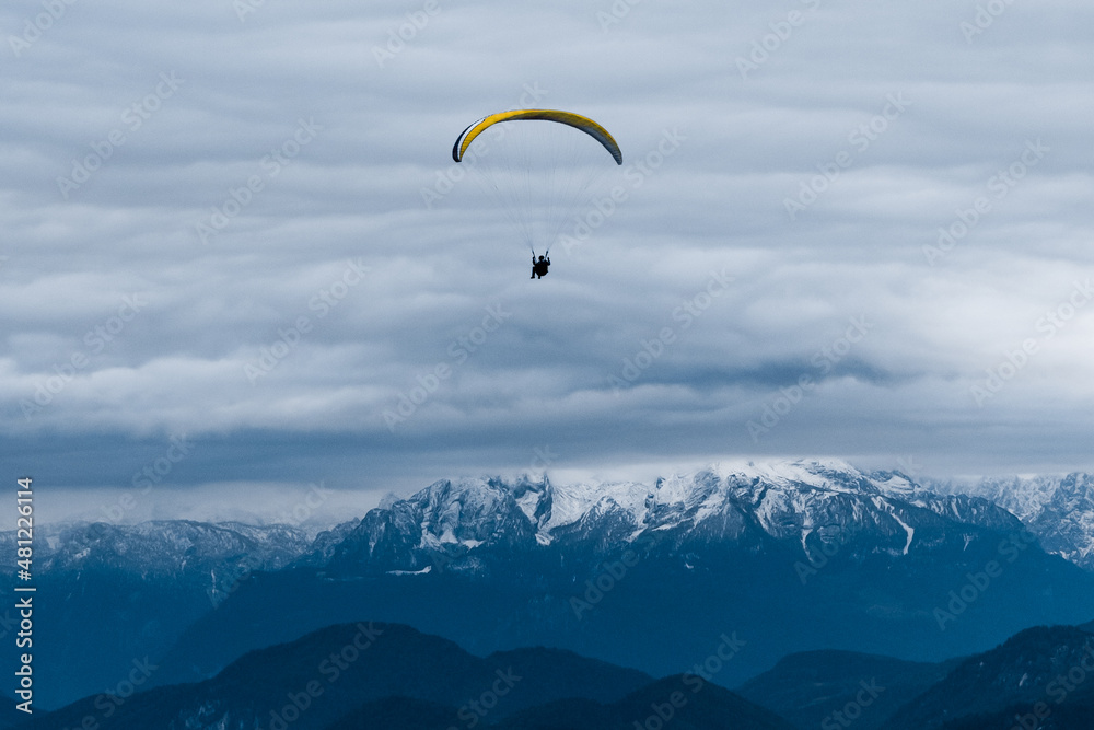 Traveler flying on paraglider over mountains Traveler flying on paraglider over mountains