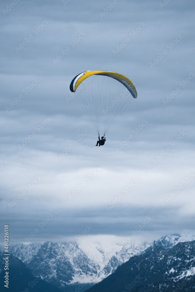 Traveler flying on paraglider over mountains Traveler flying on paraglider over mountains