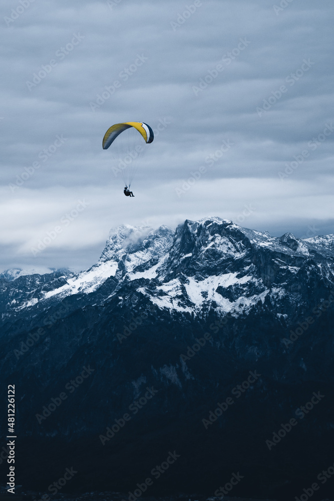 Traveler flying on paraglider over mountains Traveler flying on paraglider over mountains