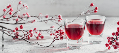 Two glasses of cherry liqueur on white background