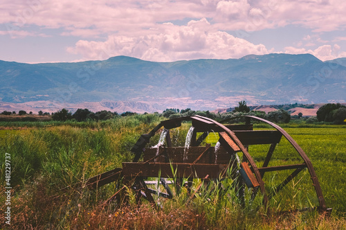 Rice field and Old wooden watermill. Antique waterwheel in the countryside.