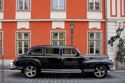 AUTO NERA VINTAGE SU SFONDO DI EDIFICIO ROSSO
