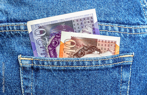British banknotes stick out of the blue jeans pocket