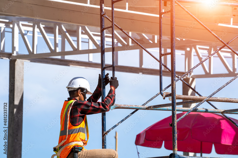 Roofer at work,Construction worker wearing safety harness and safety line working at high place at house building site. Roofer at work,Construction worker wearing safety harness and safety line working at high place at house building site.