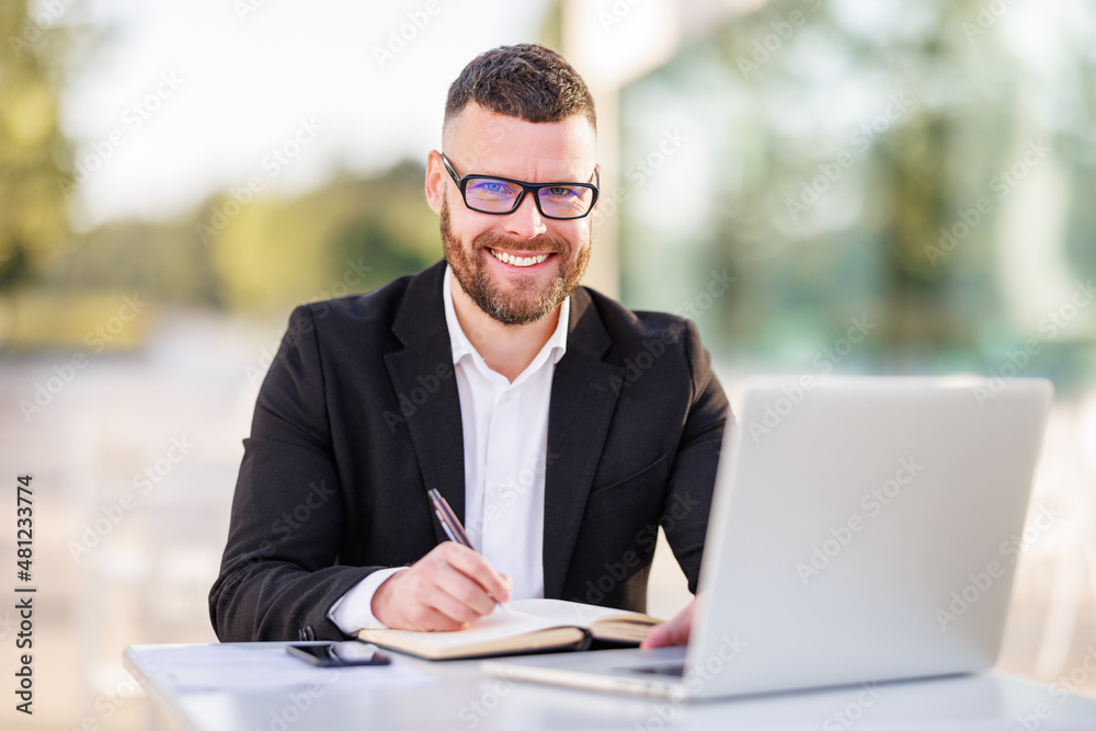 Handsome young man entrepreneur having cup of coffee while holding meeting online outside in cafe Handsome young man entrepreneur having cup of coffee while holding meeting online outside in cafe